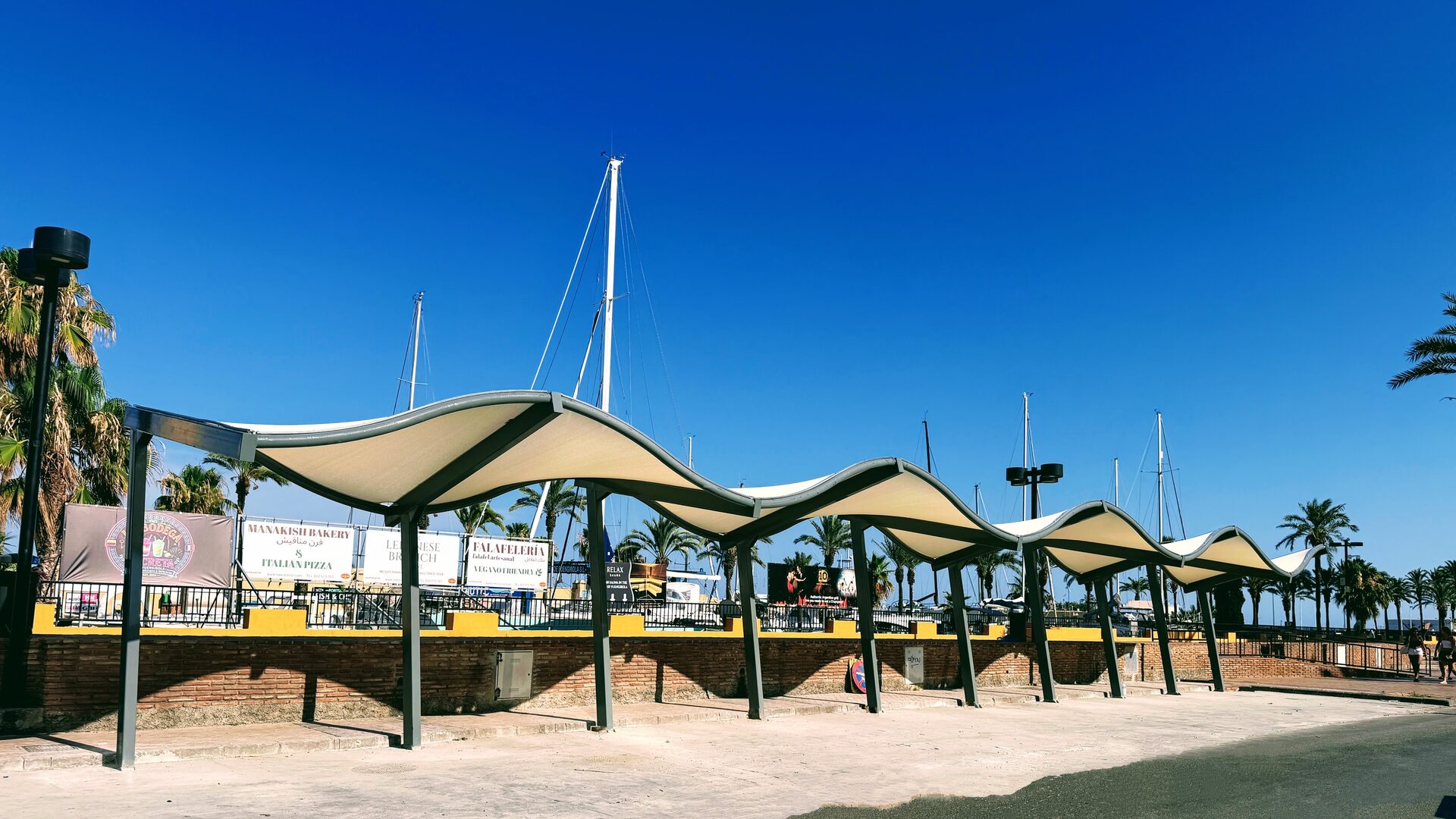 Marquesinas de cubierta ondulada junto a un puerto deportivo